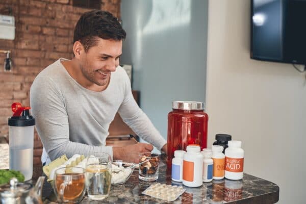 Dark-haired sportsman making a list of dietary supplements