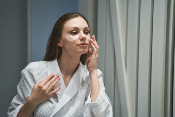 Lady moisturizing her skin under the eyes